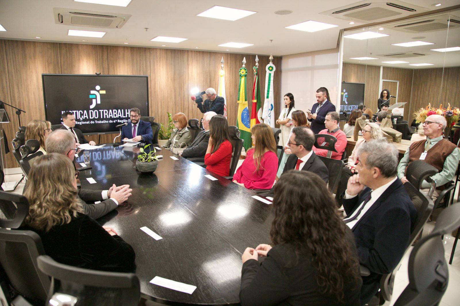 A foto mostra todos na mesa e reunião.